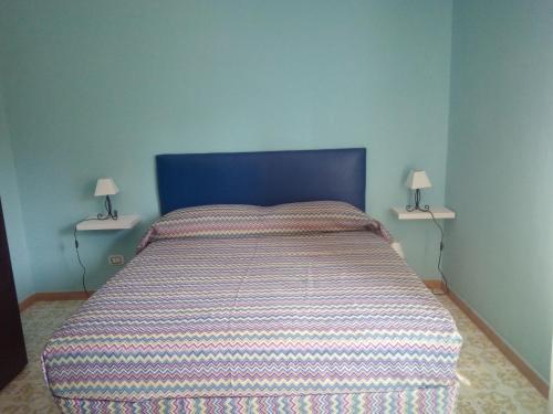 拉蒂纳Bed & Breakfast LA TERRAZZA的卧室内的一张带条纹棉被的床