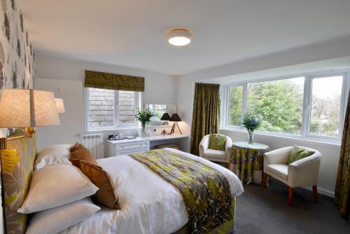 柯库布里塞尔扣克纹章酒店的一间卧室配有一张床、一张书桌和两个窗户。