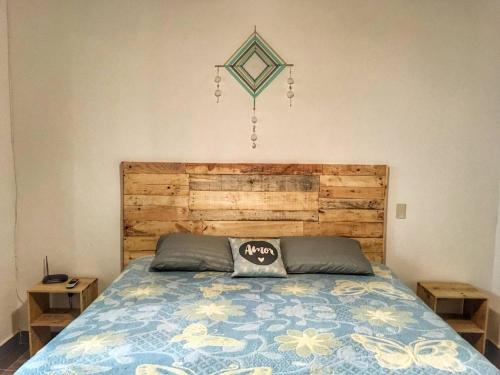 萨尤利塔Apartamento Areca #的一间卧室配有一张带木制床头板的床