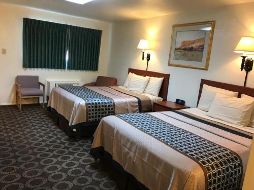 蒙蒂塞洛峡谷汽车旅馆的酒店客房,配有两张床和椅子