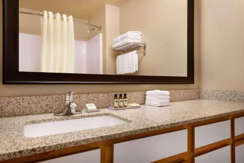 密尔沃基Hawthorn Suites By Wyndham Oak Creek/Milwaukee Airport的一间带水槽和镜子的浴室