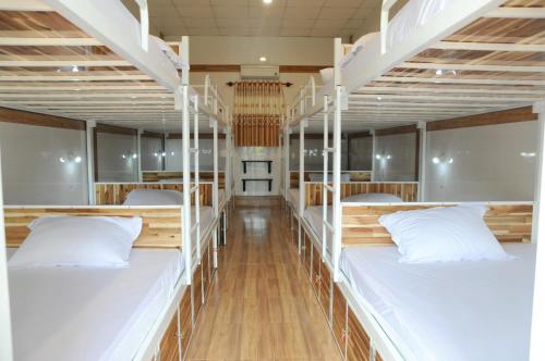 美奈Hoang Nga Garden Guesthouse的宿舍间的两张双层床位 - 带白色枕头