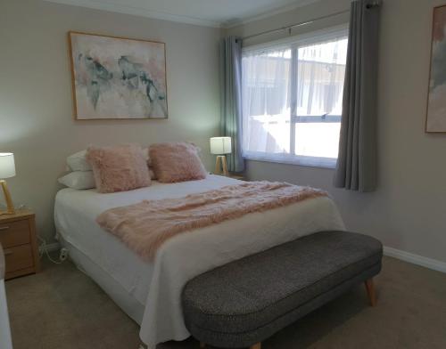 罗托鲁瓦Rose Apartments Unit 5 Central Rotorua- Accommodation & Spa的一间卧室设有一张大床和一个窗户。