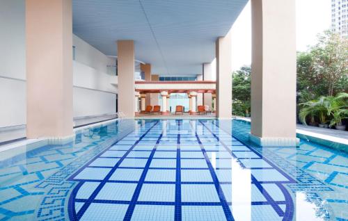 吉隆坡吉隆坡丝卡梅淘瓦酒店的大楼内带蓝色瓷砖地板的游泳池