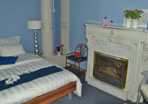 赫伦特Hotel Het Gasthof的一间带壁炉的卧室和一张位于客房内的床