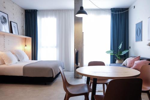 圣塞瓦斯蒂安Talo Urban Rooms的酒店客房配有一张床铺和一张桌子。