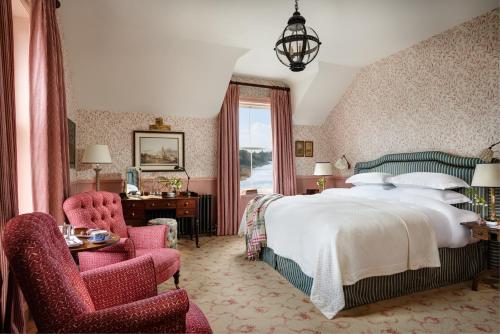 巴里那赫恩奇巴利纳城堡酒店的一间卧室配有一张大床和两把椅子