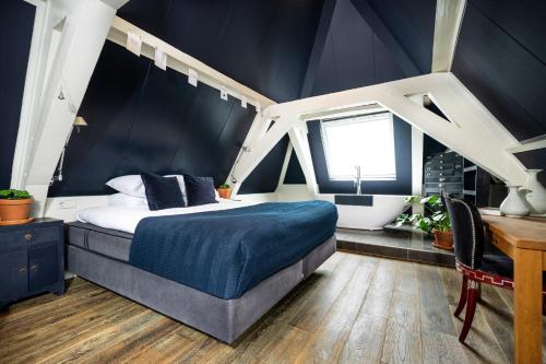 乌得勒支Anne&Max Boutique Hotel的一间卧室配有一张床、一张书桌和一个窗户。