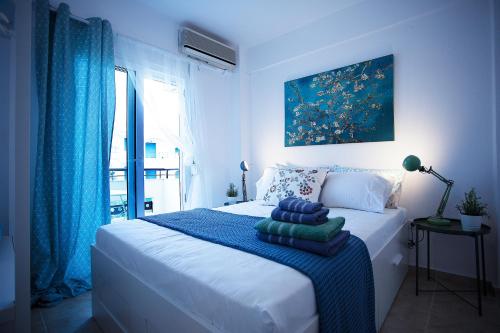 卡利塞亚-豪客迪克斯Cozy Suite Kallithea的一间卧室配有一张白色的床和蓝色的毯子
