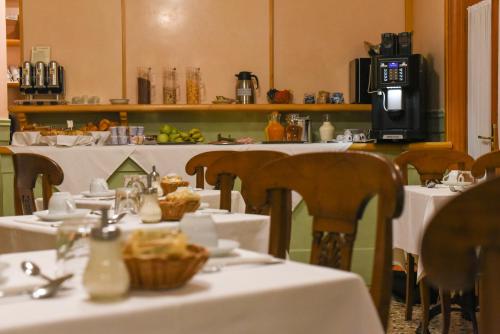 威尼斯帕拉索香东皮亚诺安蒂科酒店的用餐室配有桌椅和白色桌布