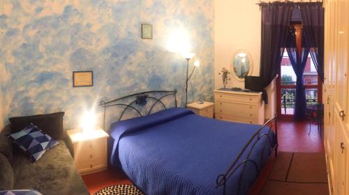 马瑞纳迪卡拉拉Eco B&B I Due Oleandri的一间卧室配有一张床和蓝色图案的墙壁