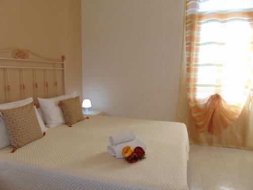 圣维托罗卡波Case Vacanza Donatella的卧室配有带鲜花的白色床