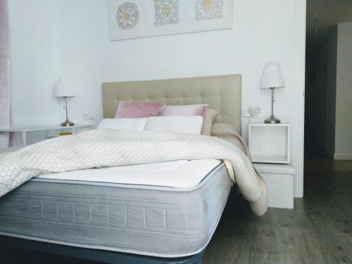阿尔姆尼卡Playa Cabria的白色卧室配有一张带两盏灯的大床