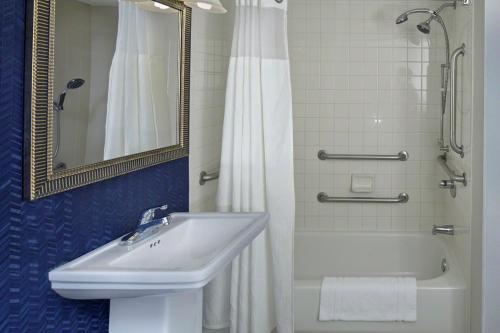德斯坦SummerPlace Inn的浴室配有水槽、淋浴和浴缸。