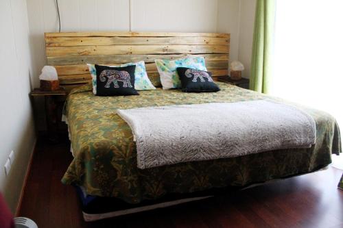 维库尼亚Casa Ollagua的一间卧室配有一张带木制床头板和枕头的床。