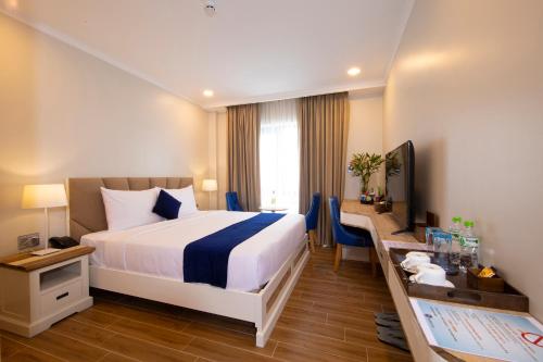 胡志明市Sabina Boutique Hotel 2的酒店客房设有一张大床和一张书桌。