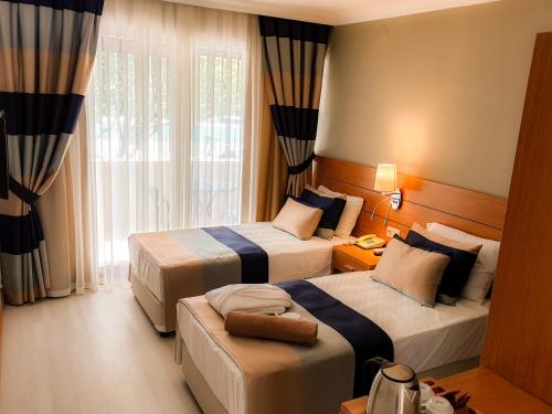 马纳夫加特Master Family Club的酒店客房设有两张床和窗户。
