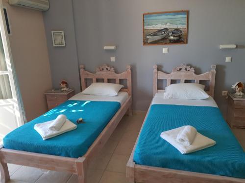 Livadi AstypalaiasKarabo Hotel的两张睡床彼此相邻,位于一个房间里