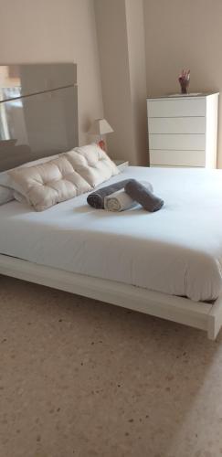珀特萨普拉亚Mirant el Mar的一张带白色床单和帽子的床