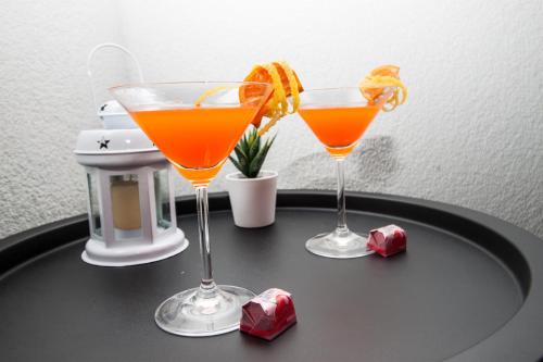 杜布罗夫尼克Ora Luxury Rooms的两个鸡尾酒坐在黑桌边,有冰块