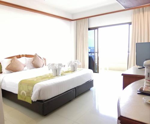 宋卡绿色世界皇宫酒店的一间卧室设有一张床和一个大窗户