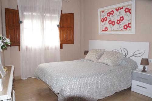 阿尔玛格鲁Apartamento Salvador 37的卧室配有一张床,墙上挂有绘画作品