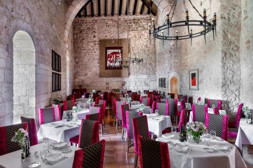 阿拉尔孔阿拉尔孔酒店的用餐室配有白色桌子和粉红色椅子