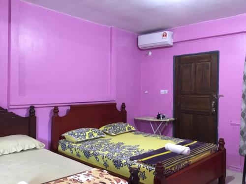 仙本那Family Room (Pakej G2)的卧室设有紫色墙壁、床和门