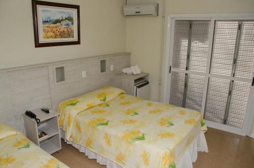 弗洛里斯-达库尼亚Dona Adelia Hotel e Restaurante的一间卧室设有两张床和窗户。