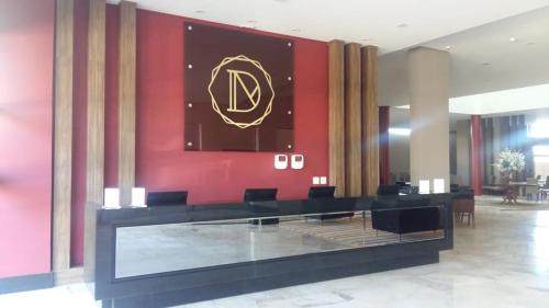 隆德里纳Dunamys Hotel Londrina的大堂设有红色的墙壁,上面有鹰熊的标志
