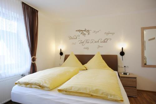 恩斯特温尼贝格霍夫酒店的一张带黄色枕头的床和墙上的标志