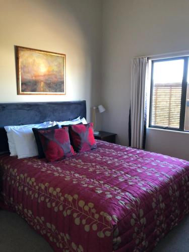 奥阿库尼Foot of Turoa Chalet的卧室配有一张大紫色床和窗户