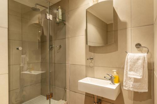 开普敦NYC Style Downtown Duplex的带淋浴、盥洗盆和镜子的浴室