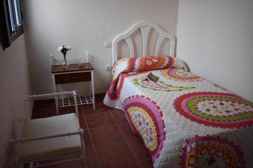 阿雷西费Ático estación的一间卧室配有一张床和一张带被子的桌子