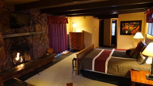 塞多纳塞多纳旅社的一间卧室配有一张床和一个石头壁炉