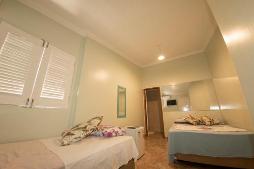 嘎林海斯港Recanto do Aconchego的一间卧室配有两张床和镜子
