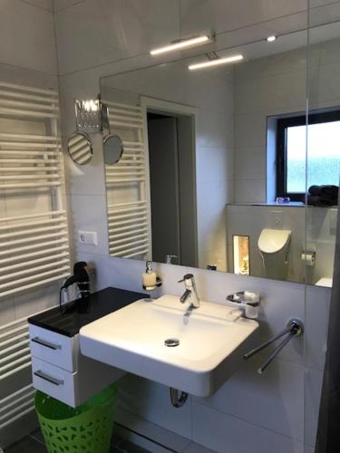 诺斯罗驰Nußloch am Bach Kick Appartment的浴室设有白色水槽和镜子