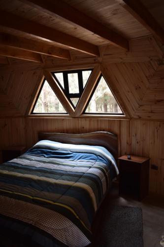 Santa BárbaraDomos Nelkewue的木制客房的一张床位,设有窗户