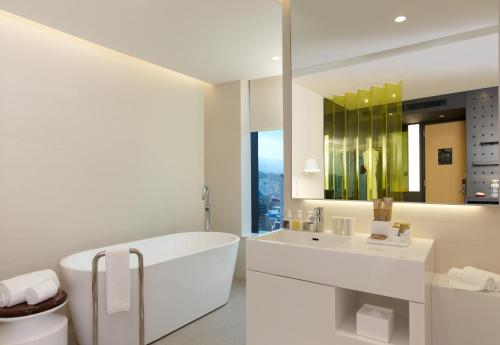 台北南港老爷行旅的白色的浴室设有浴缸和水槽。