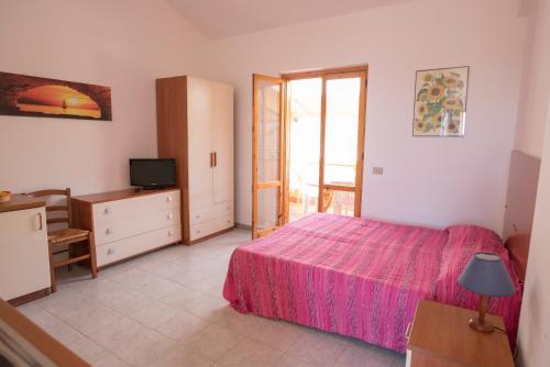 夏卡Case Vacanza Renella 3 beds: Balcony, wifi, self-catering, 200mt from the sea的卧室配有粉红色的床和电视。
