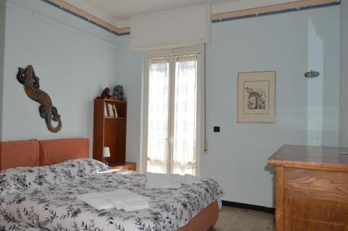 莱圭利亚Appartamento "Abbracciando il Mare"的一间卧室配有一张床、一张书桌和一个窗户。