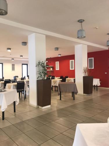 圣贝内代托-德尔特龙托Hotel Royal的一间带桌椅和红色墙壁的餐厅