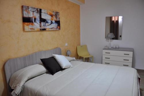 利扎诺House Le Fontanelle的卧室配有白色大床和梳妆台