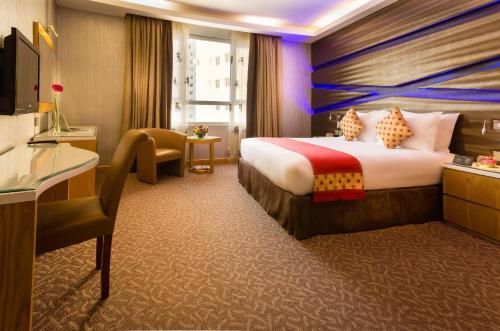 麦纳麦Al Safir Hotel的酒店客房带一张大床和一把椅子