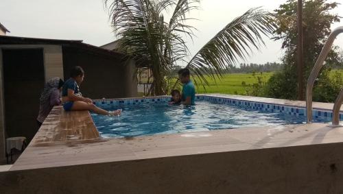 Kuala Kurau库劳旅馆农庄的一群人站在游泳池周围