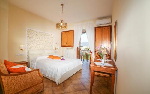 斯卡拉Ravello View的一间卧室配有一张床、一把椅子和一张桌子