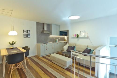 卢布尔雅那城市中心公寓的厨房以及带沙发和桌子的客厅。