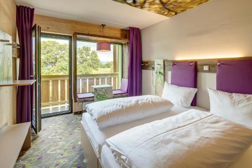 内森尔旺新天鹅堡探险家酒店的紫色墙壁和窗户的客房内的两张床