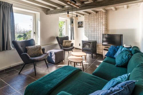 龙塞里克度假屋的客厅设有绿色沙发和壁炉