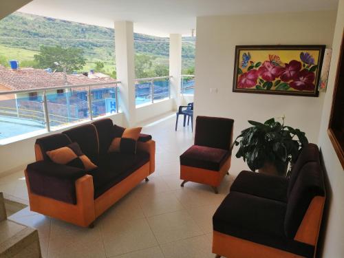 Valle de San JoséHotel el Paraíso del Valle的客厅配有两把椅子和一张沙发